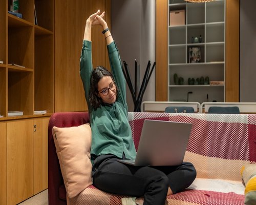 Person taking a break from laptop to stretch